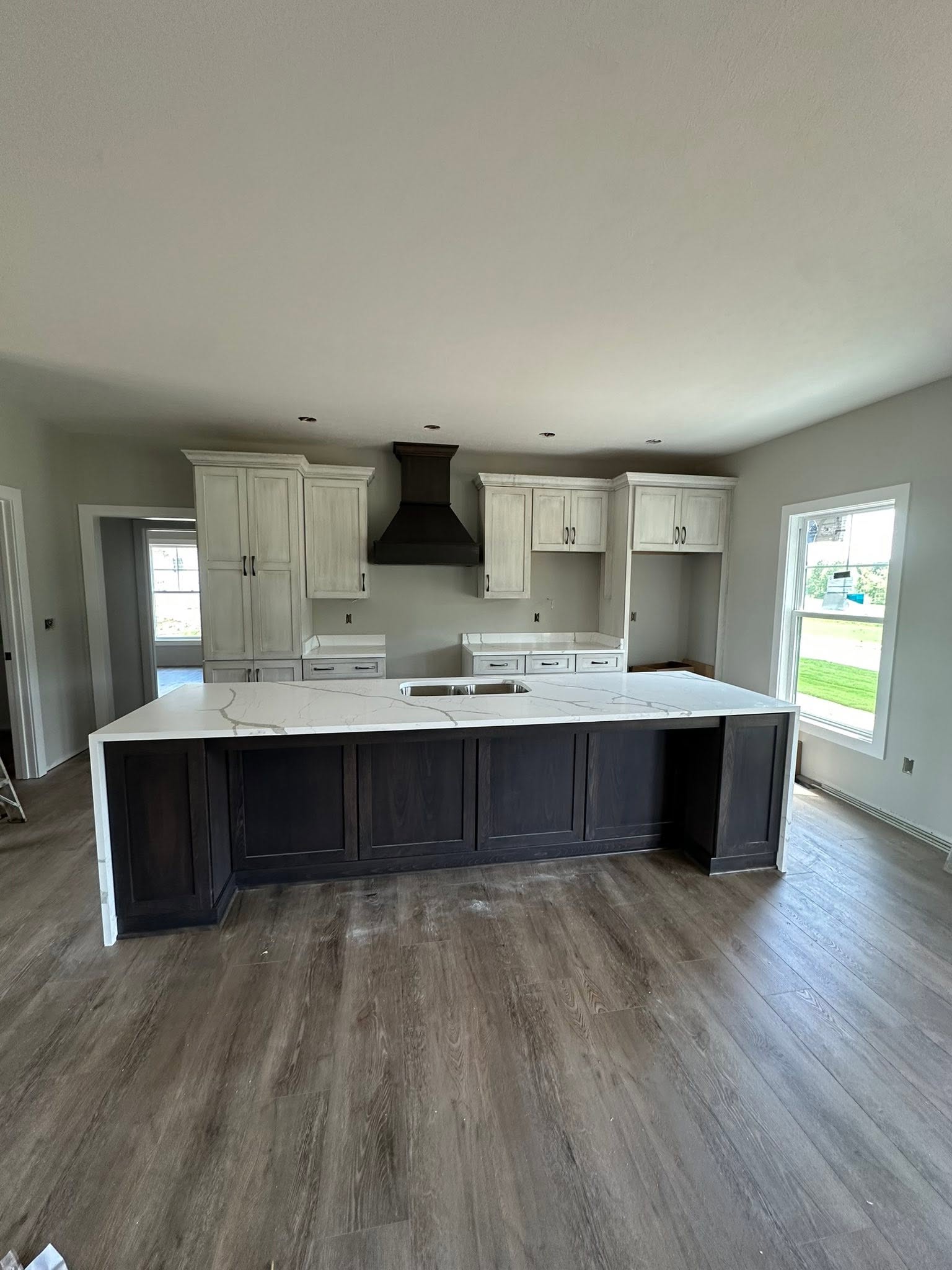 Kitchen with distressed white cabinets and a dark wood island